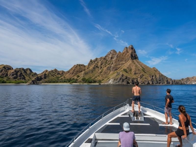 Speed boat passengers approaching the rugged hills of Padar Island in Komodo National Park