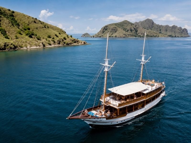 Traditional phinisi boat sailing through Komodo National Park near Labuan Bajo